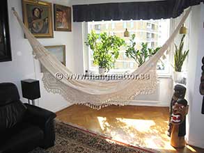 Hängmattan Amazonas upphängd som en möbel och inredningsdetalj inomhus på hängmattskrokar fästa i väggarna i en lägenhet.