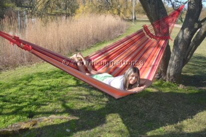 Ligger på magen och solar samt myser i hängmattan Paraíba.