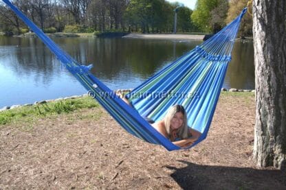 Ligger på magen och solar samt myser i hängmattan Pernambuco.