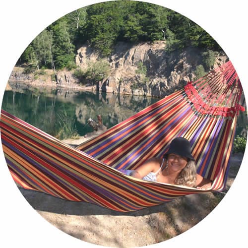 Kategori dubbelhängmattor illustreras av en tjej som ligger i hängmattan Paraná mellan 2 träd intill en sjö i ett stenbrott.